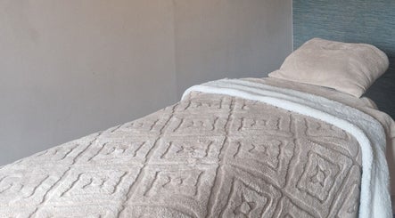 Luxurious massage bed setup at Urban Oasis Massage Therapy, Swinton, England, GB. Soft, inviting linens.