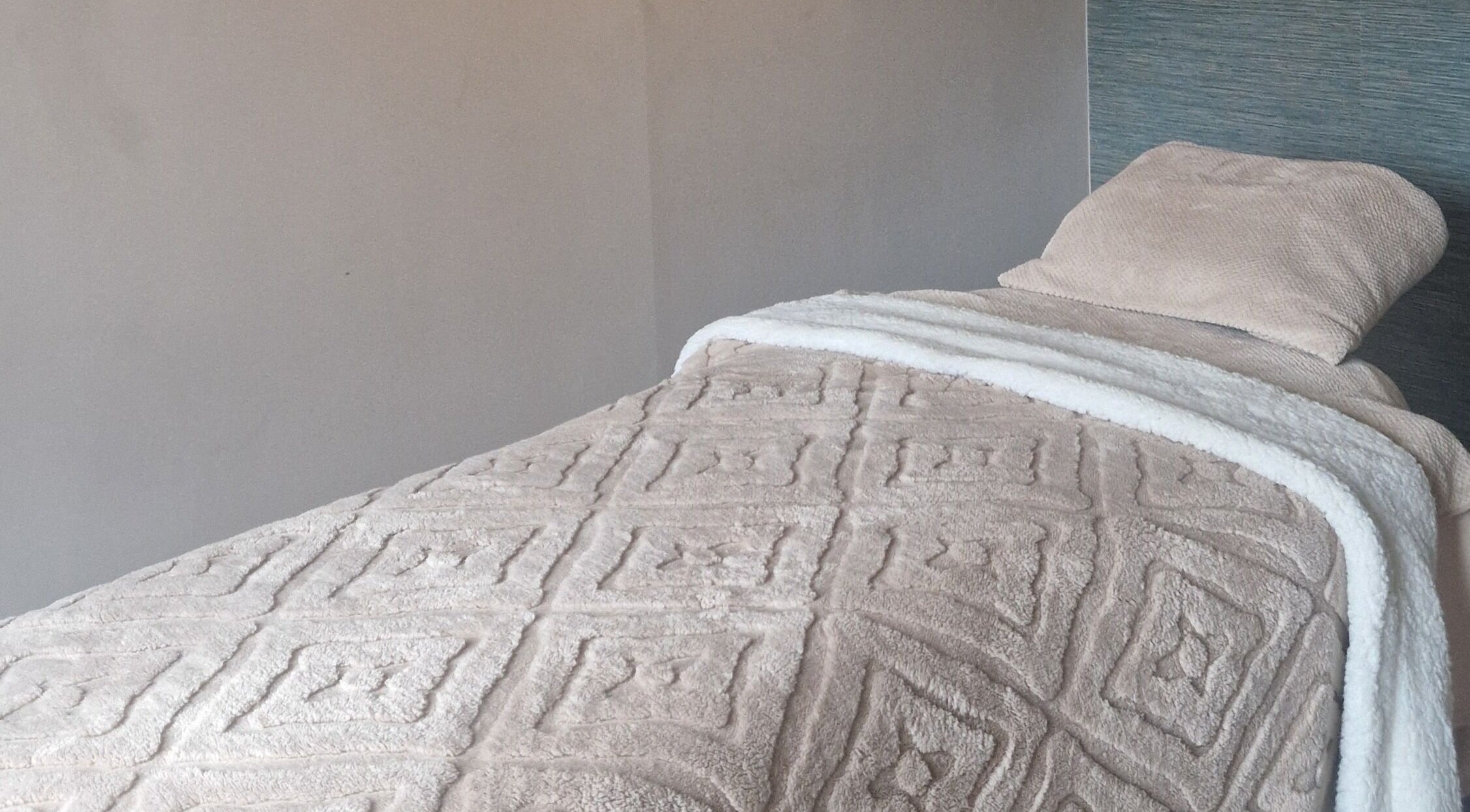 Cozy massage bed at Urban Oasis Massage Therapy in Swinton, England, GB, with soft, textured blankets.