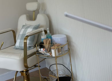 Elegant treatment chair at The Forge Beauty Room, Newsham, England, GB, with a side cart of beauty supplies.
