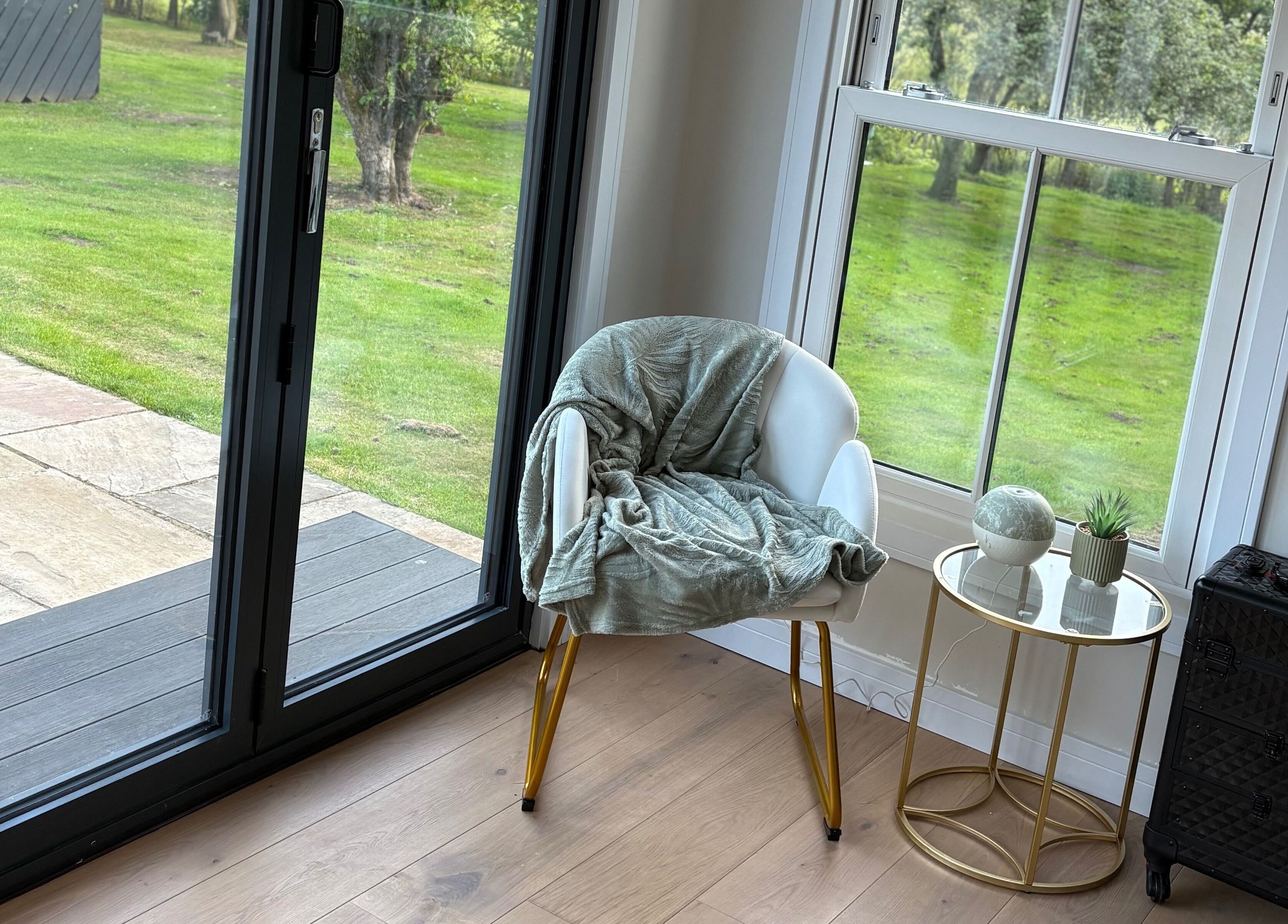 Cozy chair and table with decor at The Forge Beauty Room, Newsham, England, GB, offering a relaxing view.