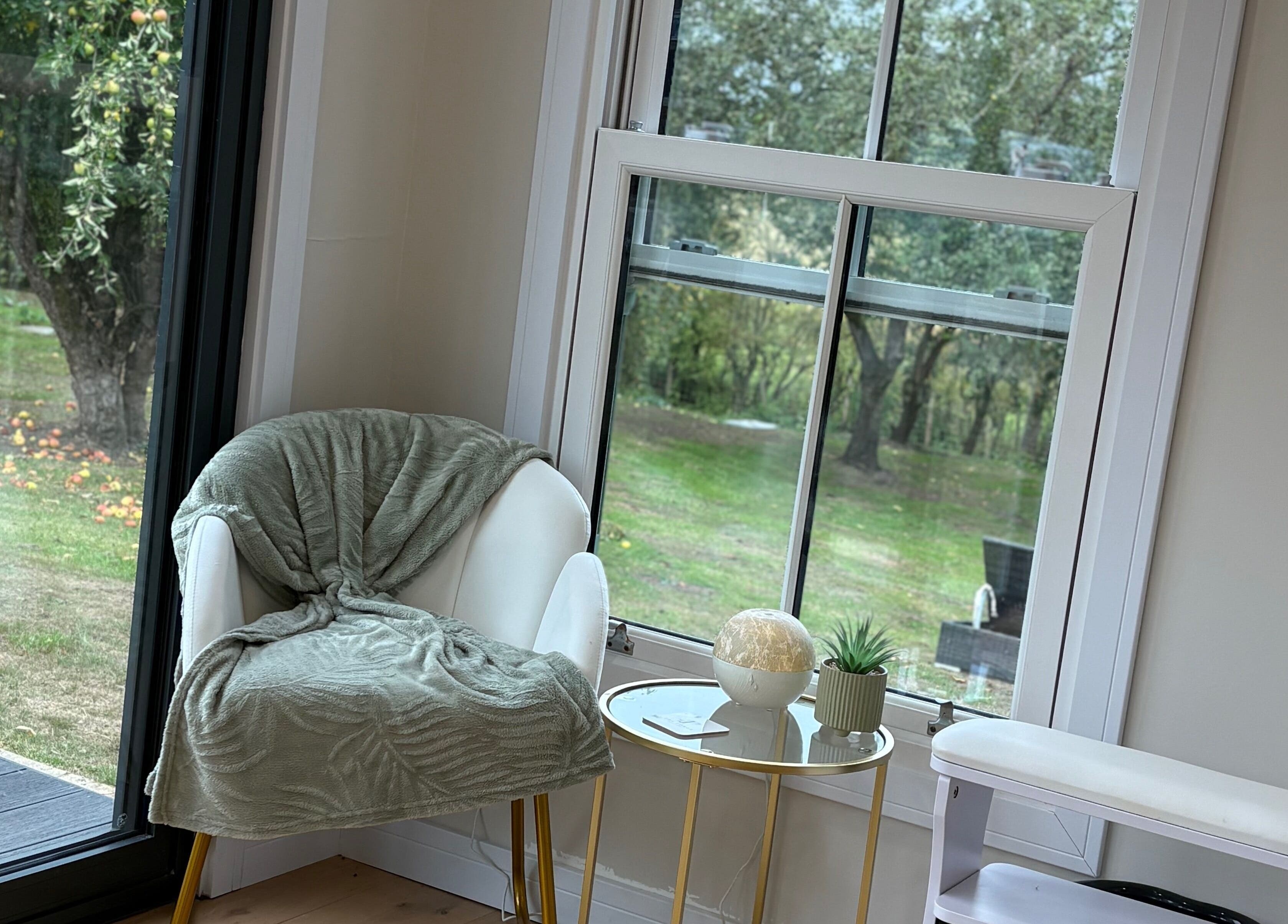 Relaxing nook at The Forge Beauty Room, Newsham, England, GB with a lush garden view.
