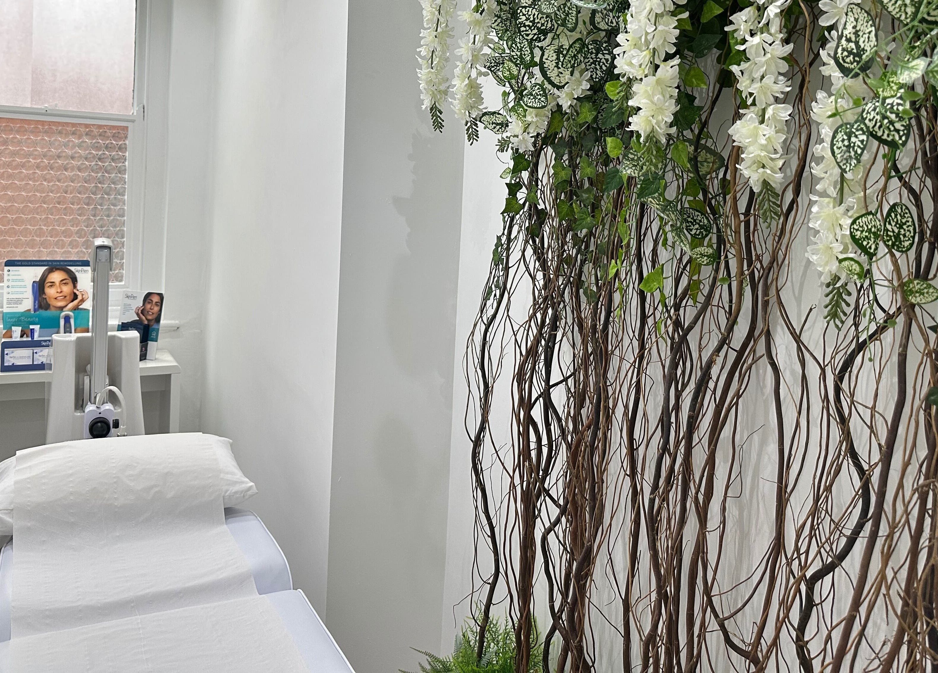 Calm treatment room with white linens and floral decor at The Private Practice (Birmingham), Birmingham, England, GB.