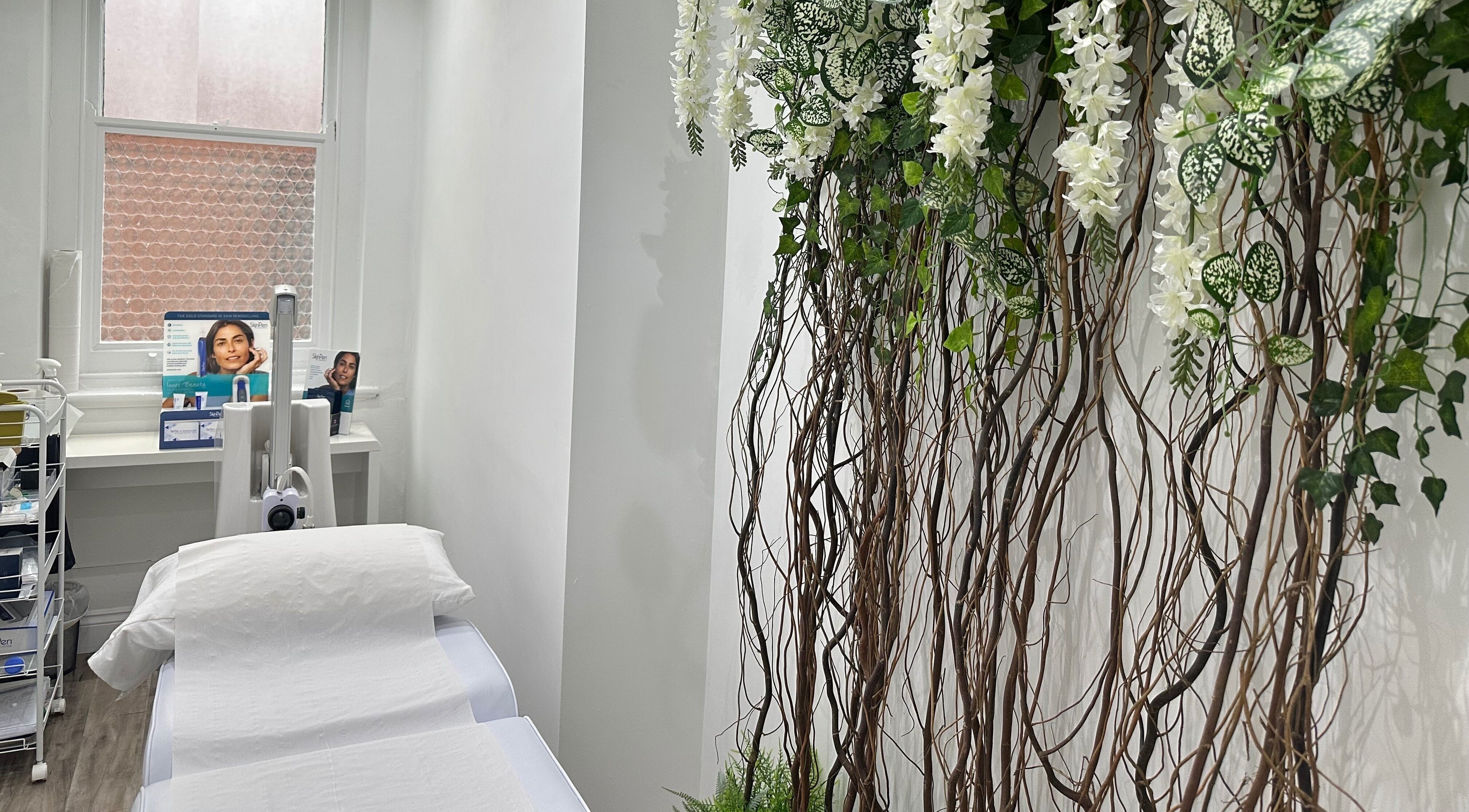 Calm treatment room with white linens and floral decor at The Private Practice (Birmingham), Birmingham, England, GB.