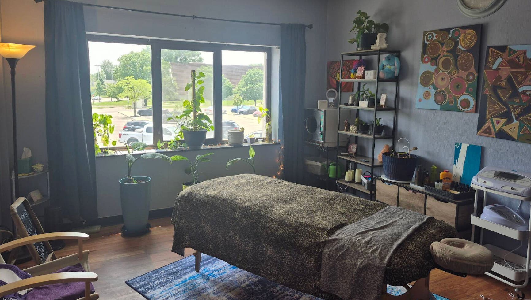 Relaxing massage room at Mo'Living Massage & Studio LLC, Columbus, Ohio, US with plants and cozy decor.
