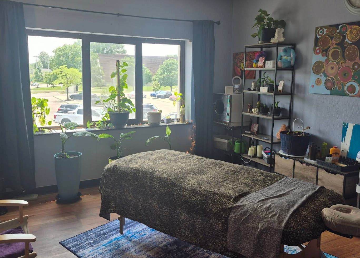 Relaxing massage room at Mo'Living Massage & Studio LLC, Columbus, Ohio, US with plants and cozy decor.