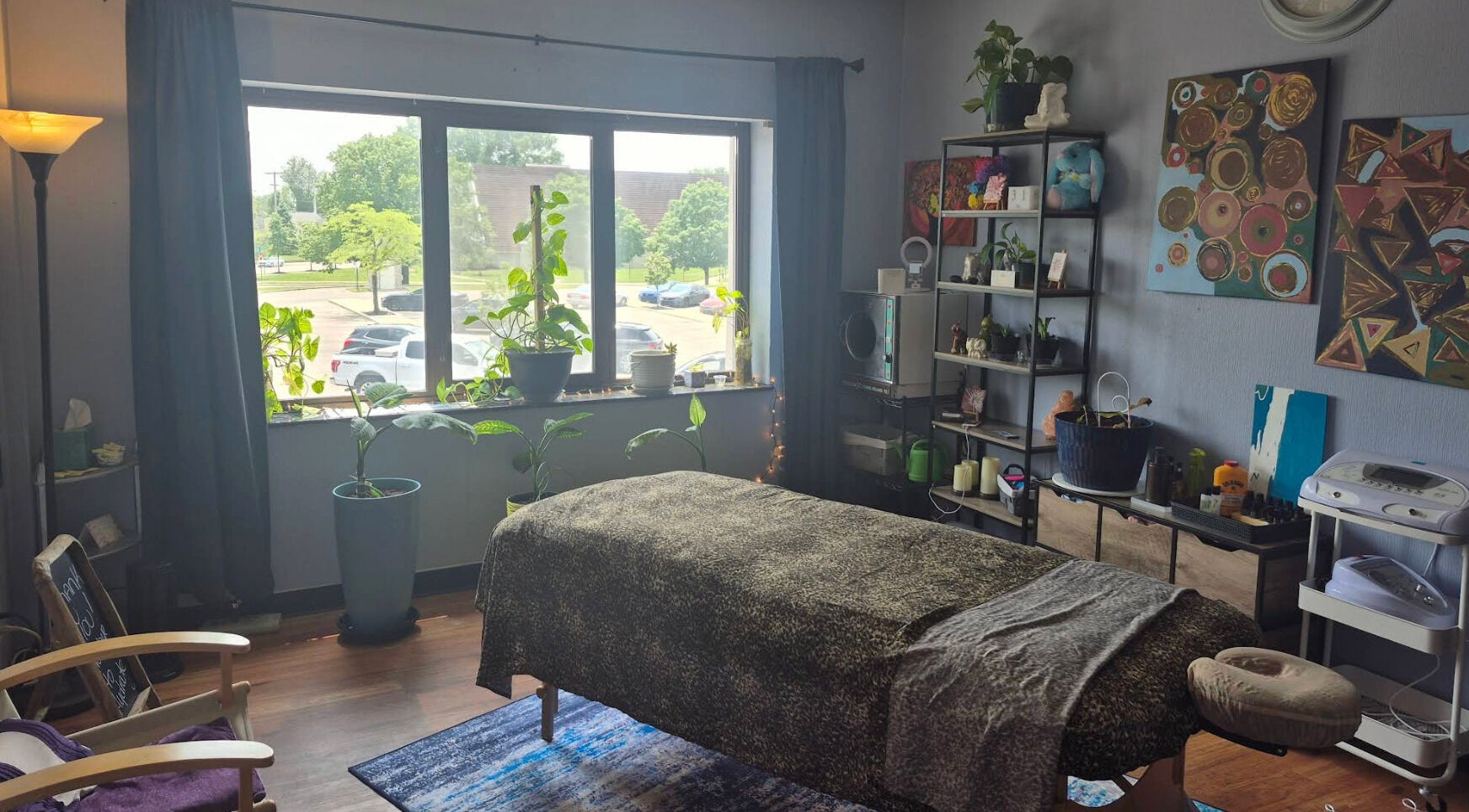 Relaxing massage room at Mo'Living Massage & Studio LLC, Columbus, Ohio, US with plants and cozy decor.