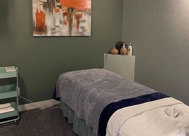 Tranquil massage room at Su Microblading & Wellness Massage, Parker, Colorado, US, with art and cozy bed.