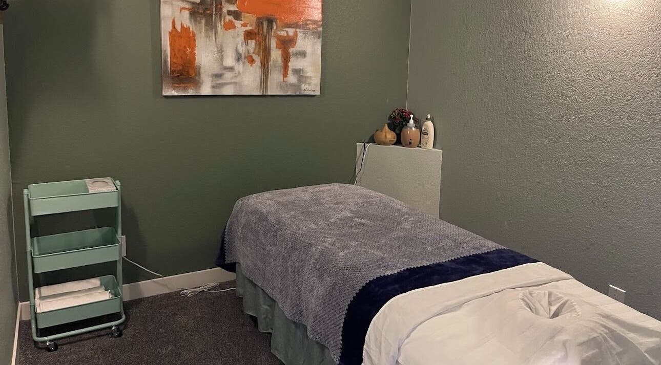 Tranquil massage room at Su Microblading & Wellness Massage, Parker, Colorado, US, with art and cozy bed.