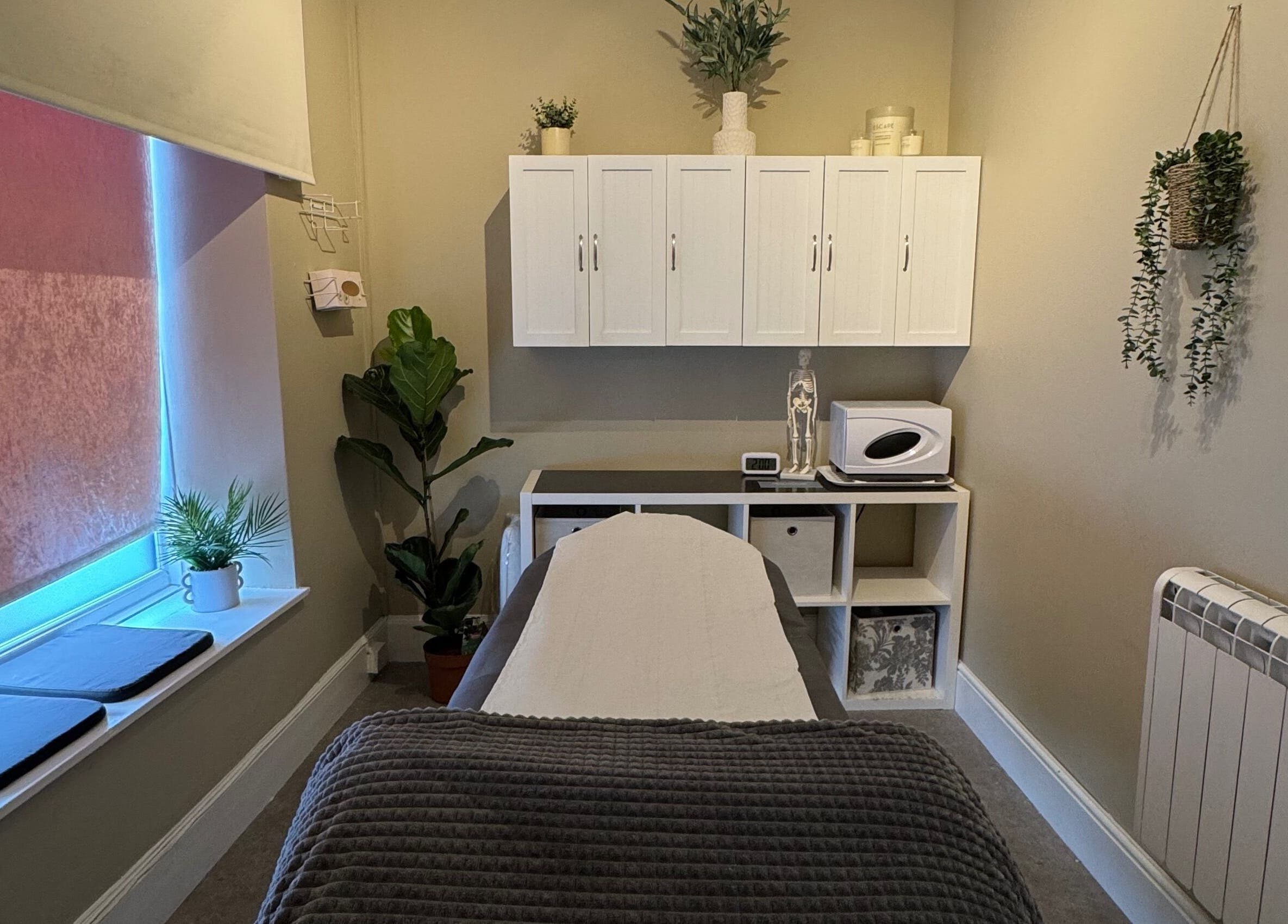 Relaxing therapy room at New Motion Sports Therapy, Bude, England, GB, with cozy decor and soft lighting.