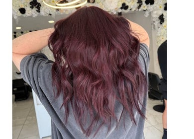 Burgundy wavy hair styled at Shelbi Halewood Hair in Prestwich, England, GB.