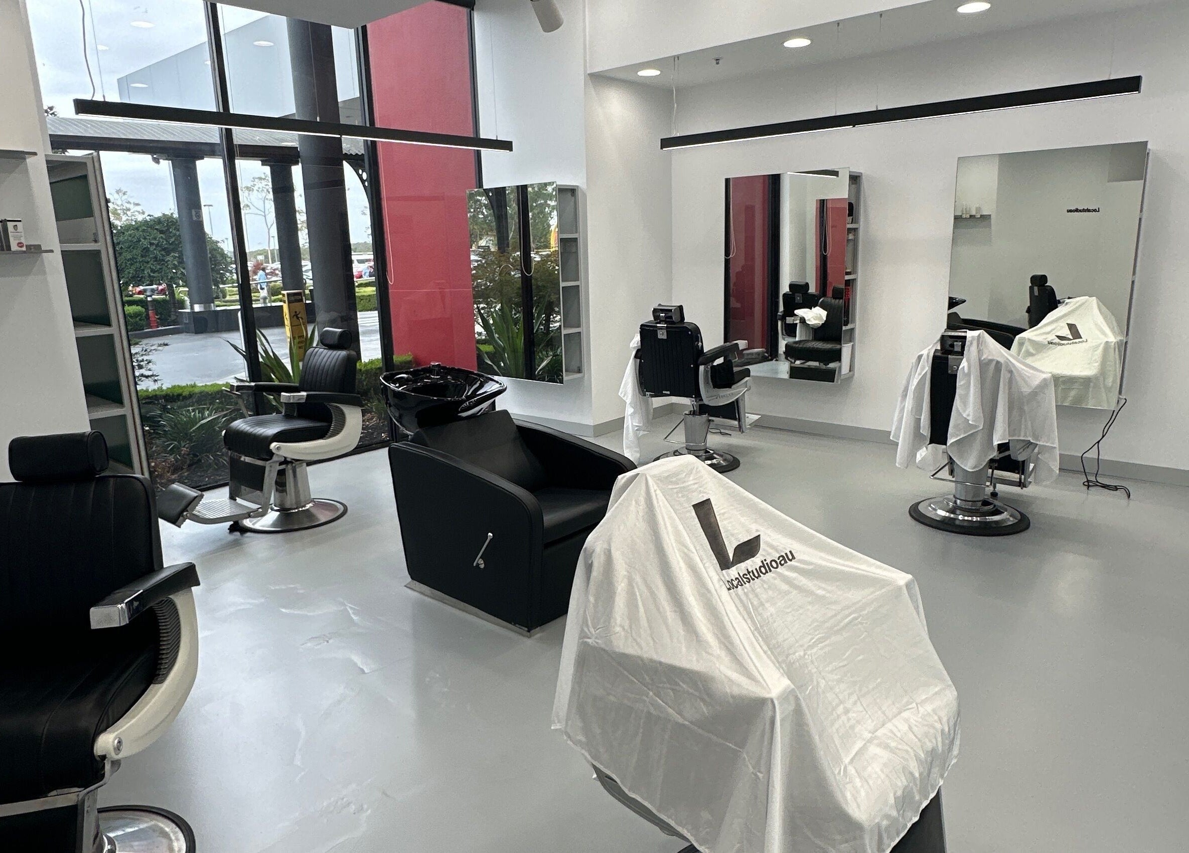 Modern salon interior at Localstudioau, Bossley Park, New South Wales, AU with chic black velvet chairs.