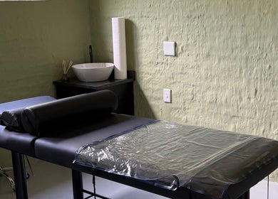 Tranquil massage room at Olive and Kai Beauty, Midrand, Gauteng, ZA, featuring a massage table and soft lighting.