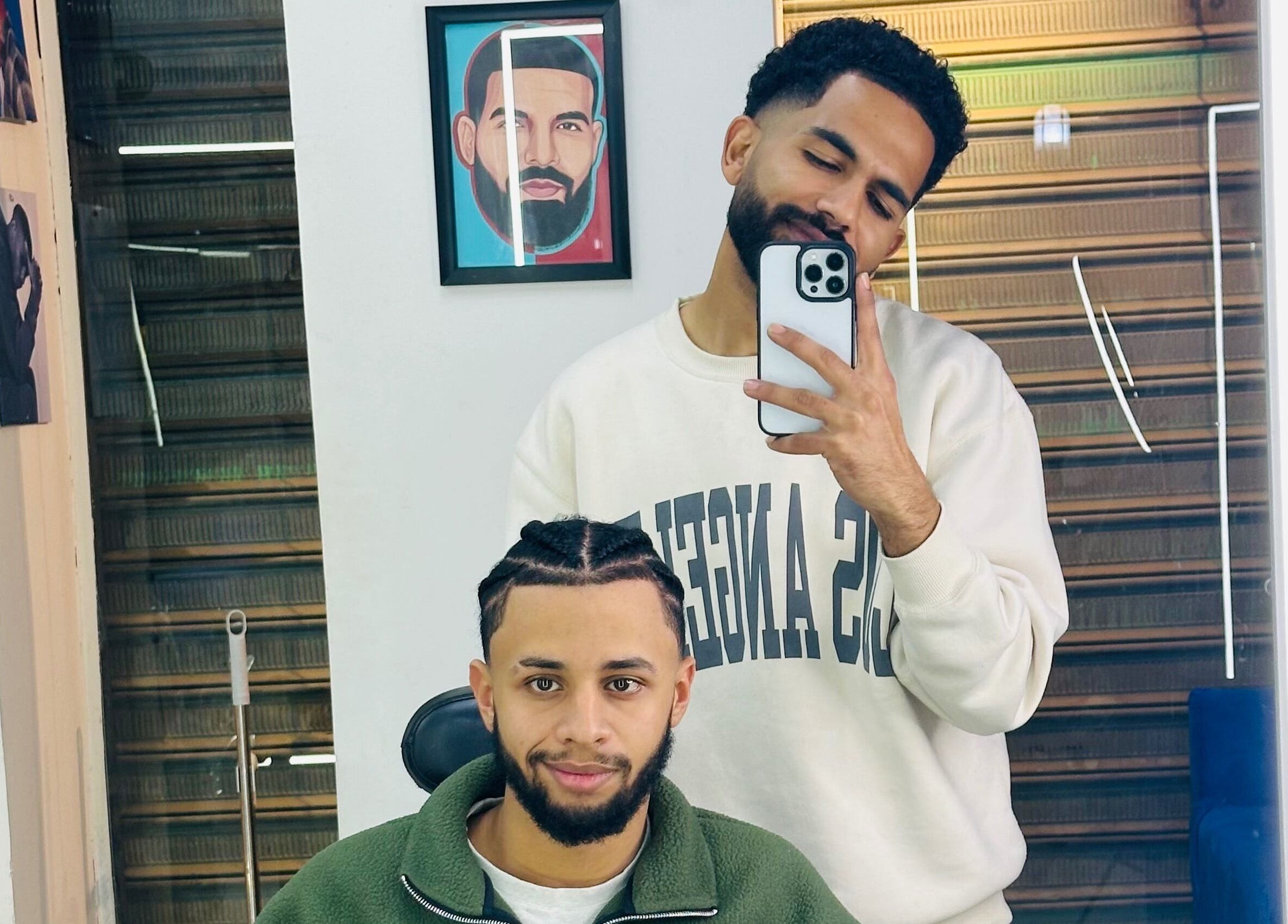 Two men at Hakim Hair Style in Cairo Governorate enjoying a fresh haircut and selfie moment.