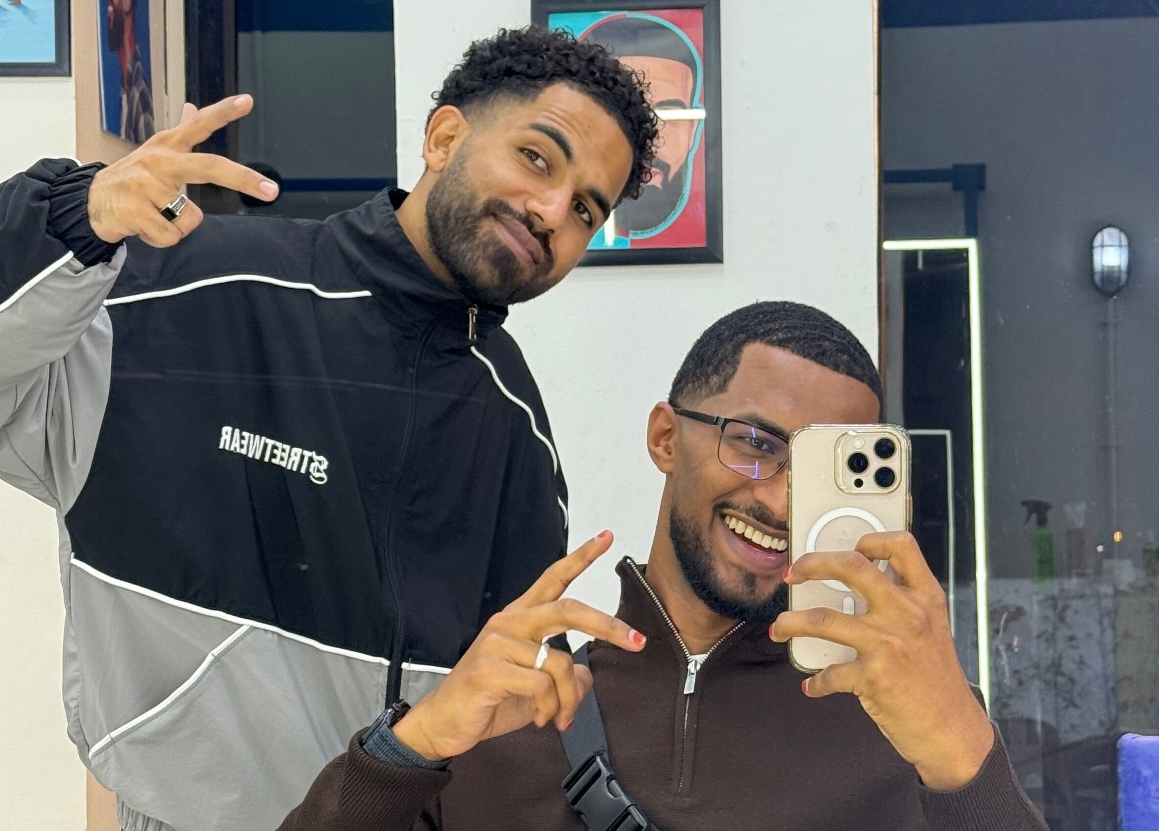 Two smiling men posing at Hakim Hair Style in Cairo Governorate, Cairo Governorate, EG.