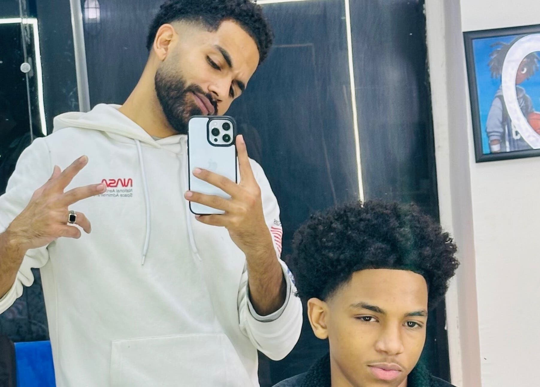 Barber and client at Hakim Hair Style, Cairo Governorate, EG, capturing a stylish haircut moment.