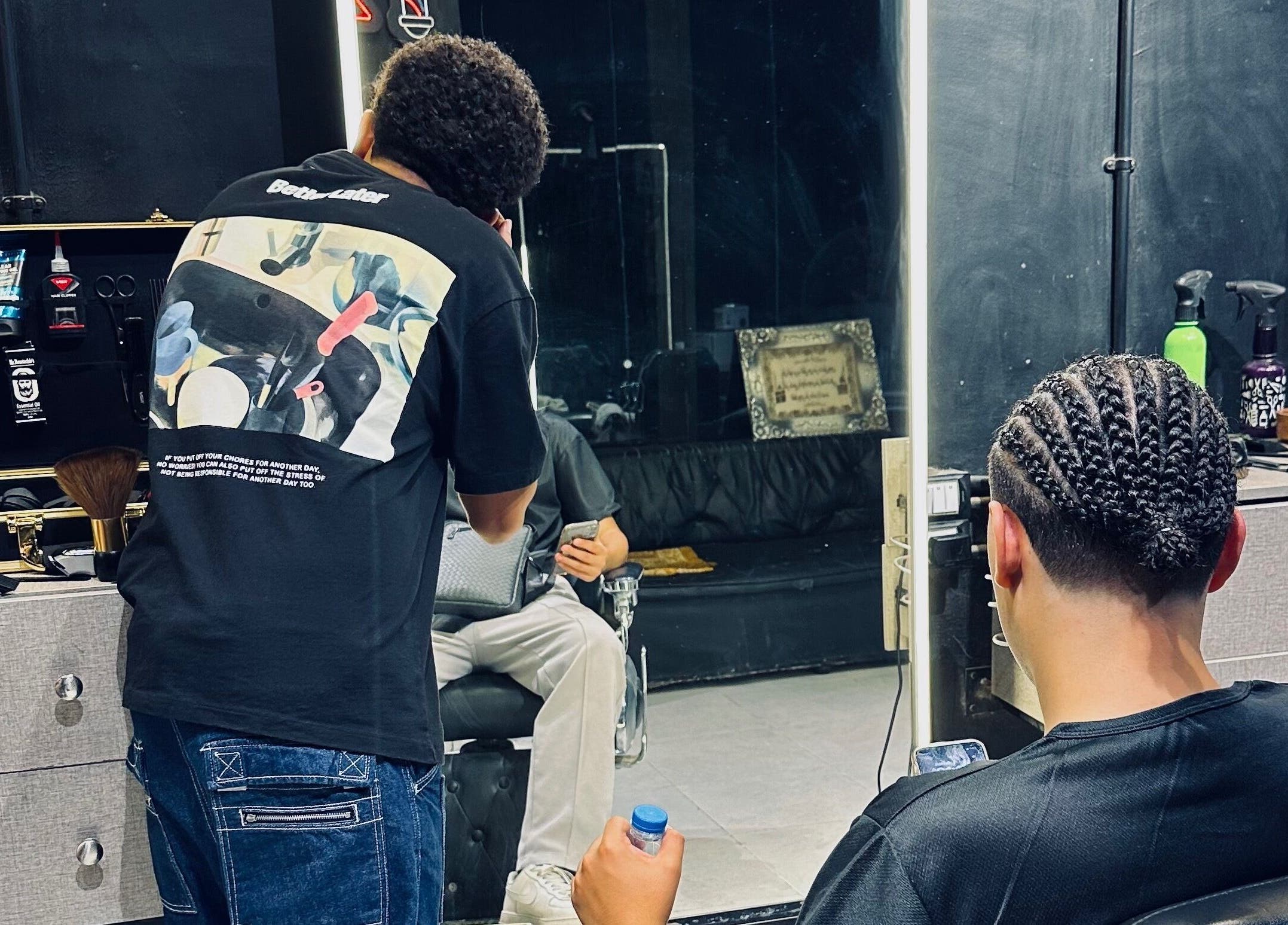 Barber styling hair with intricate braids at Hakim Hair Style, Cairo Governorate, Cairo Governorate, EG.