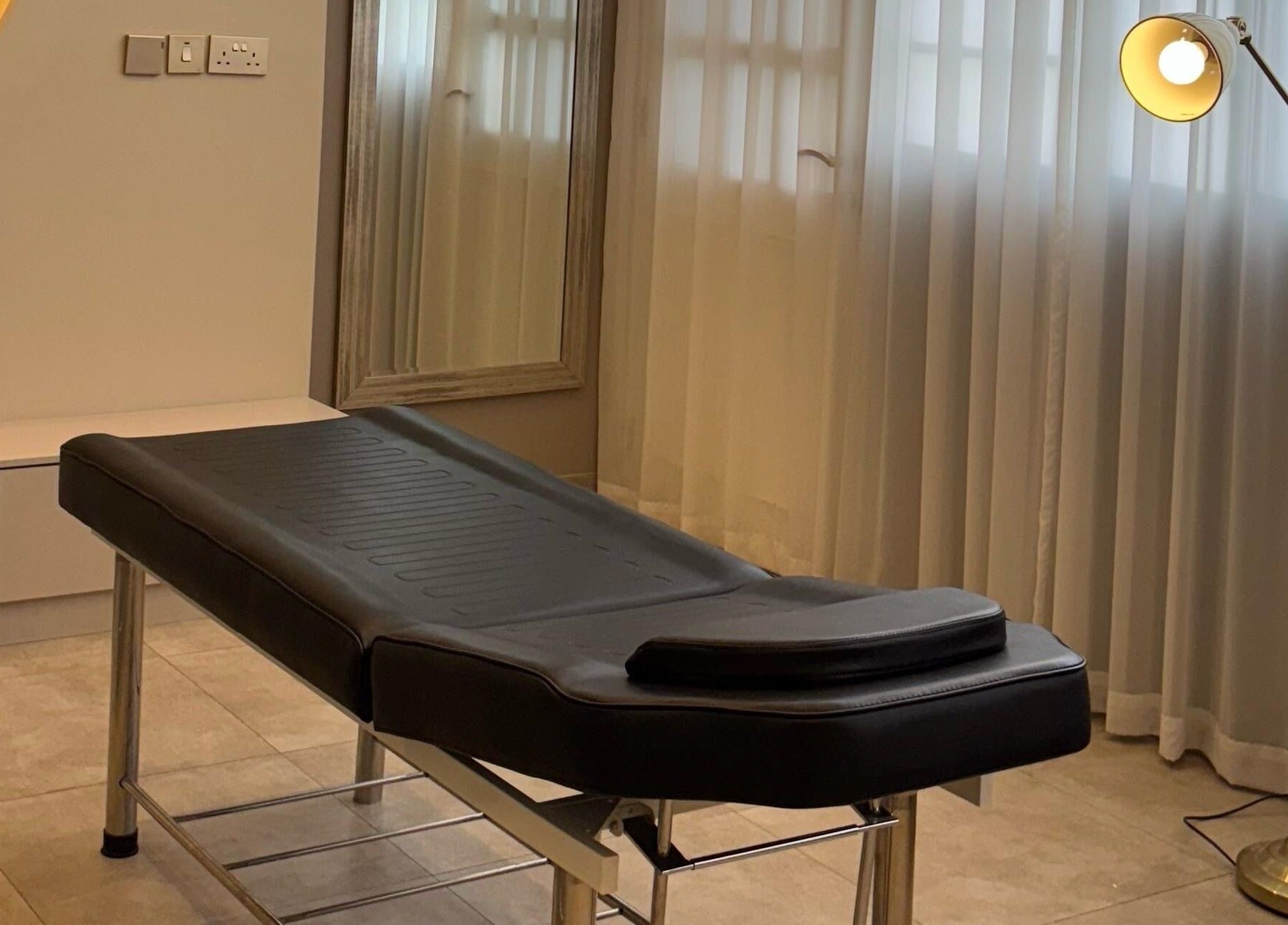 Relaxing treatment room at Farzaneh beauty salon, Muscat, Muscat, OM, with therapy bed and ambient lighting.