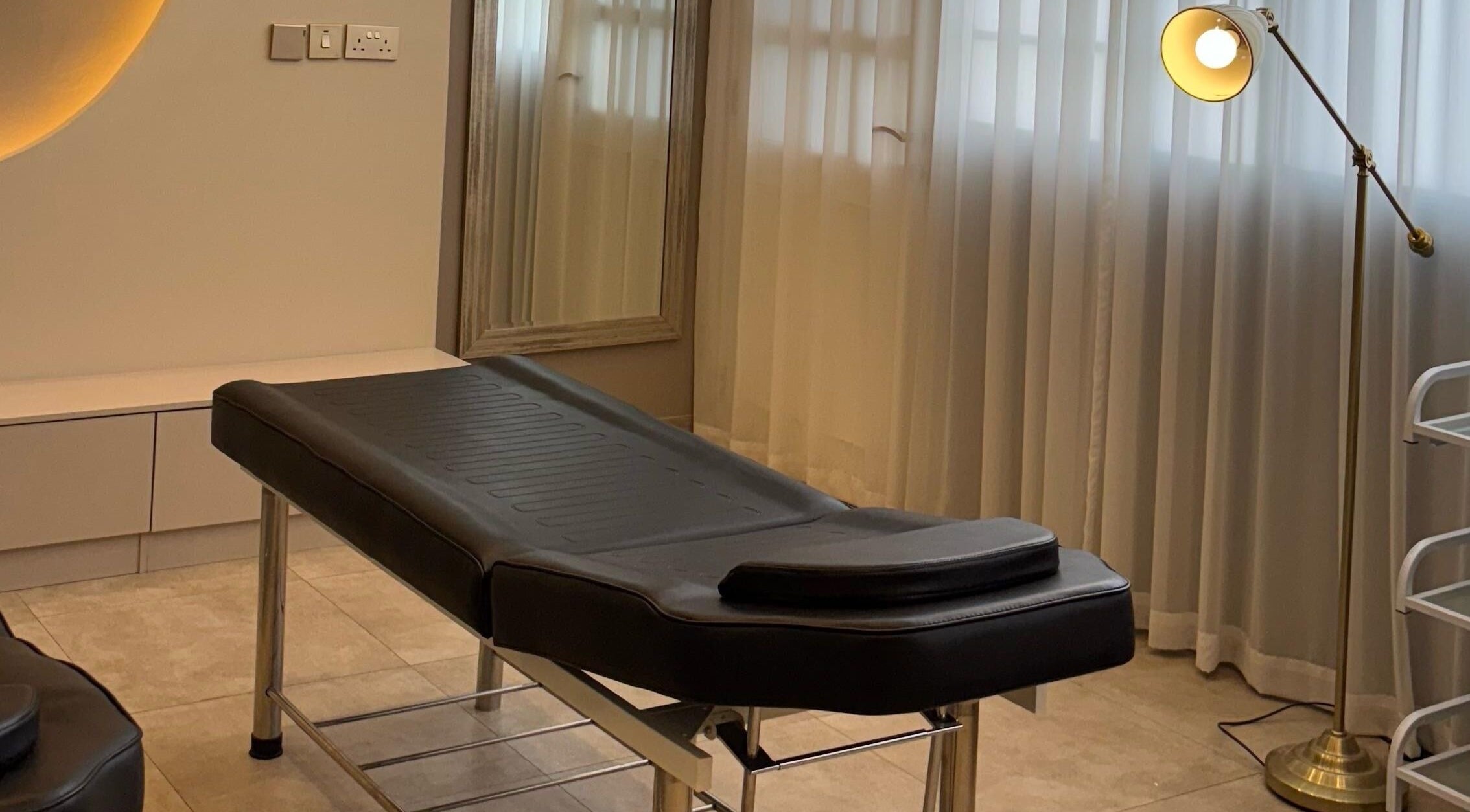 Relaxing treatment room at Farzaneh beauty salon, Muscat, Muscat, OM, with therapy bed and ambient lighting.