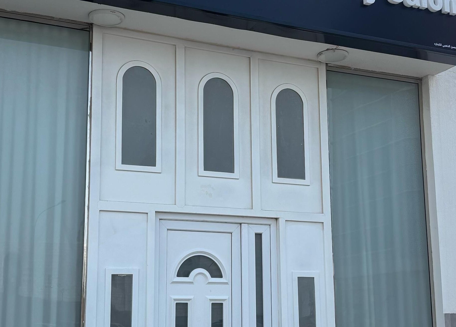 Front view of Farzaneh beauty salon in Muscat, OM, showcasing its elegant white entrance.