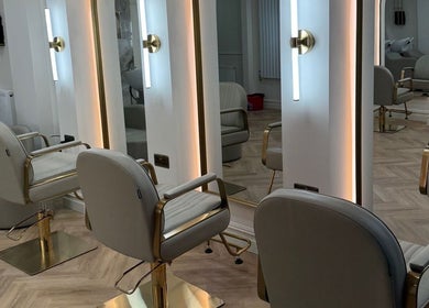 Modern salon interior at EMMLOU BEAUTY in Cheadle Hulme, England, GB with chic chairs and sleek mirrors.
