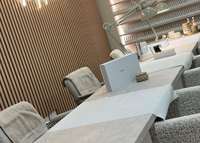 Modern nail salon interior at EMMLOU BEAUTY, Cheadle Hulme, England, GB, featuring chic manicure stations.