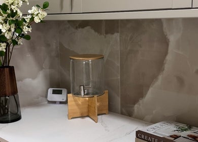 Elegant setup at EMMLOU BEAUTY, Cheadle Hulme, England. Features a vase, water dispenser, and decor book.