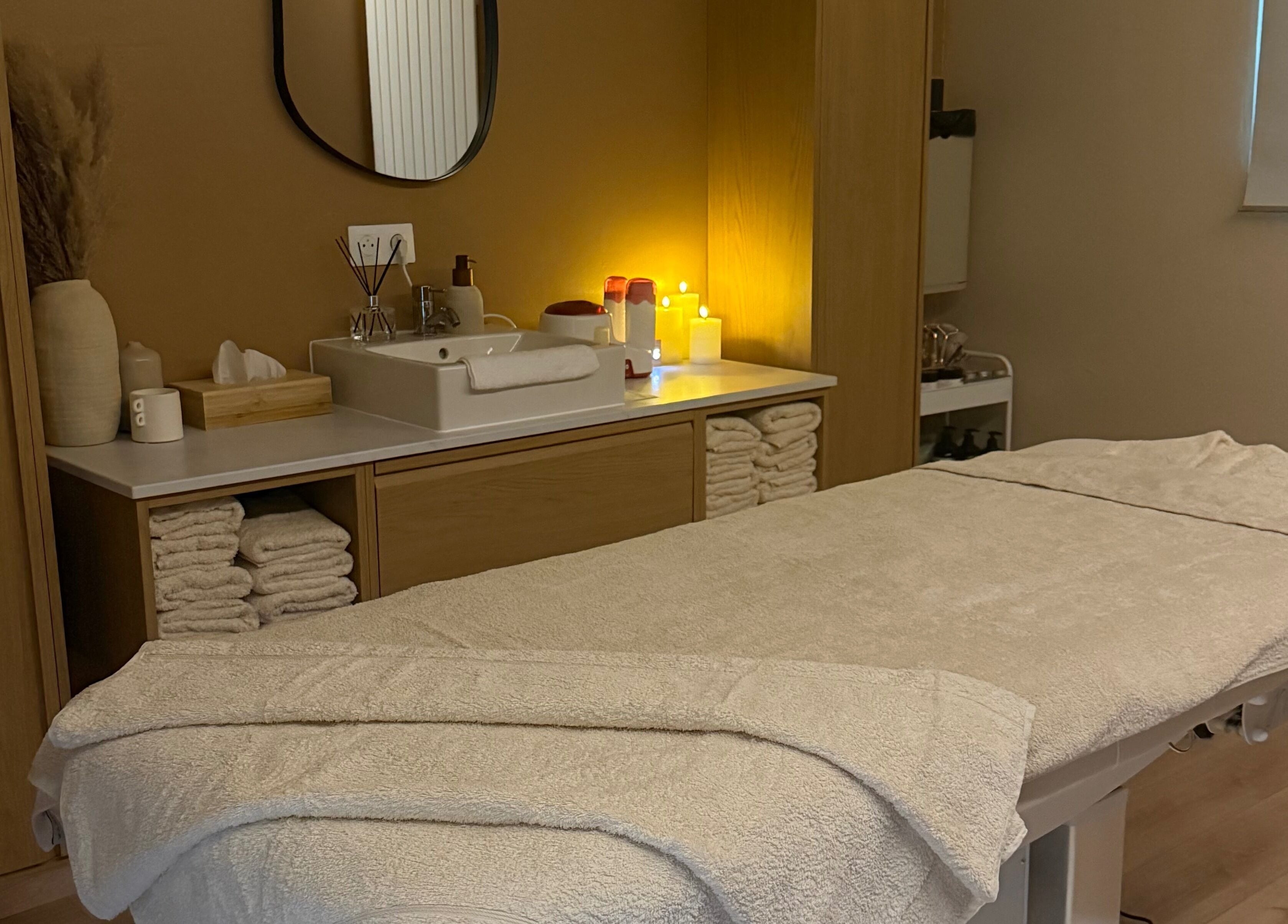 Salle de soins relaxante chez Oserenité, Aubrives, Grand Est, FR, avec table de massage et serviettes.