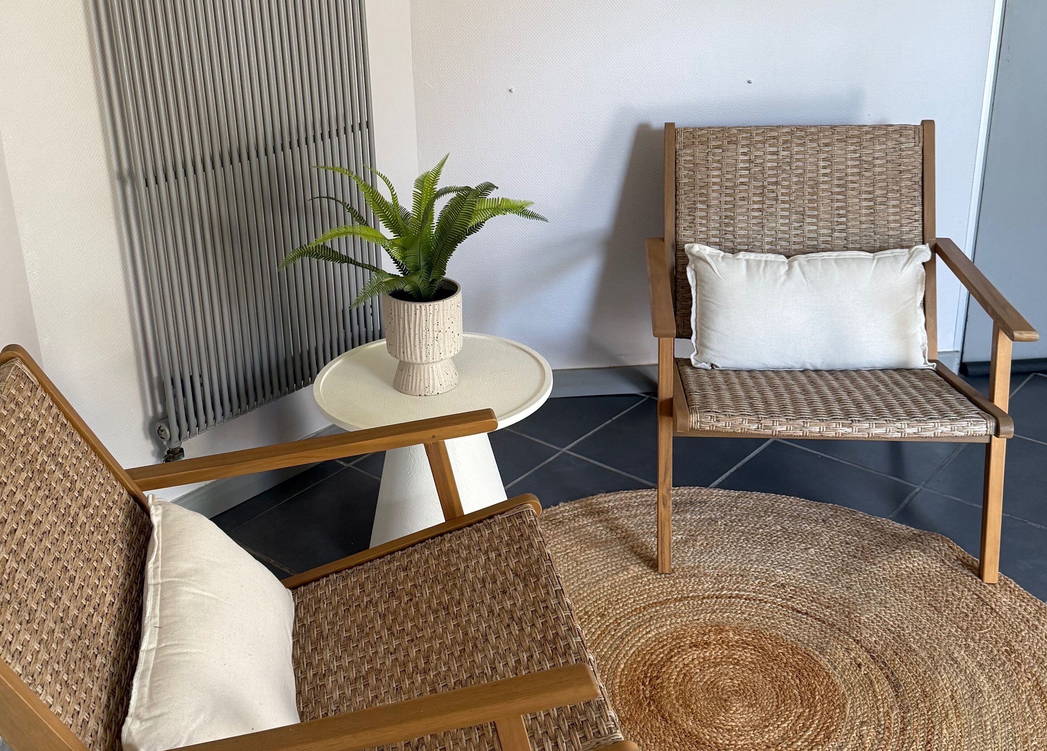 Coin détente élégant avec fauteuils en rotin à Oserenité Aubrives, Grand Est, FR.