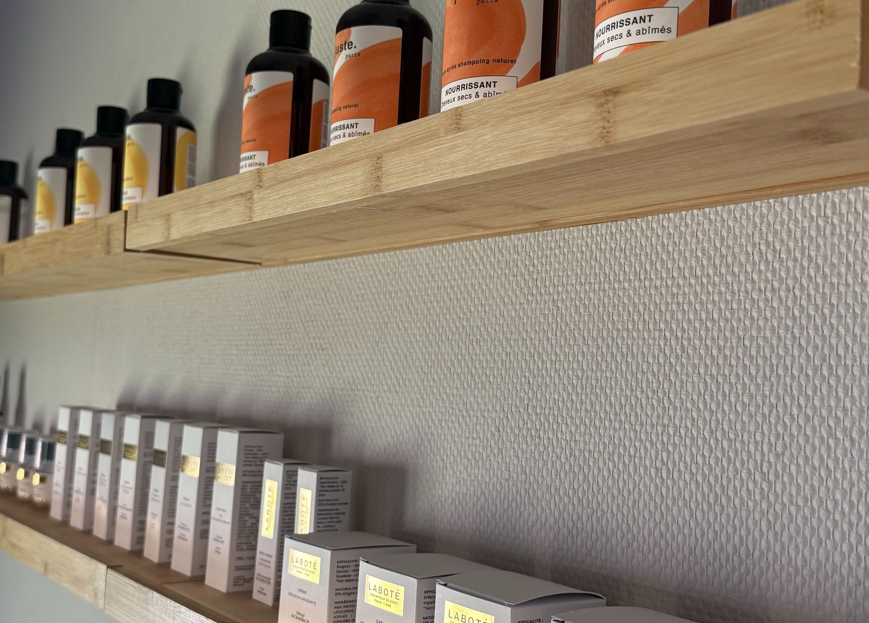 Produits de beauté sur étagères en bois à Oserenité, Aubrives, Grand Est, FR.