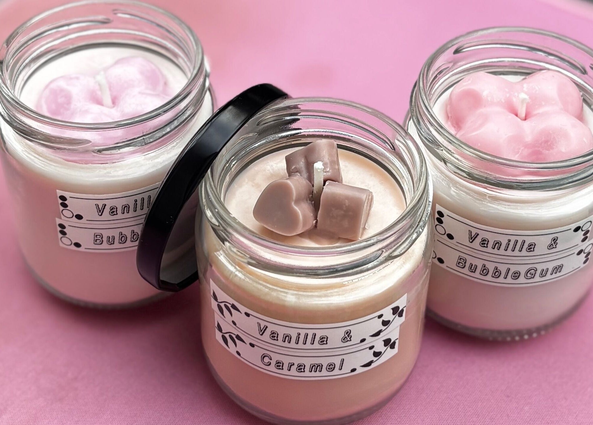 Scented candles at Executive Elegance in Dunedin, Otago, NZ, displayed on a pink background.