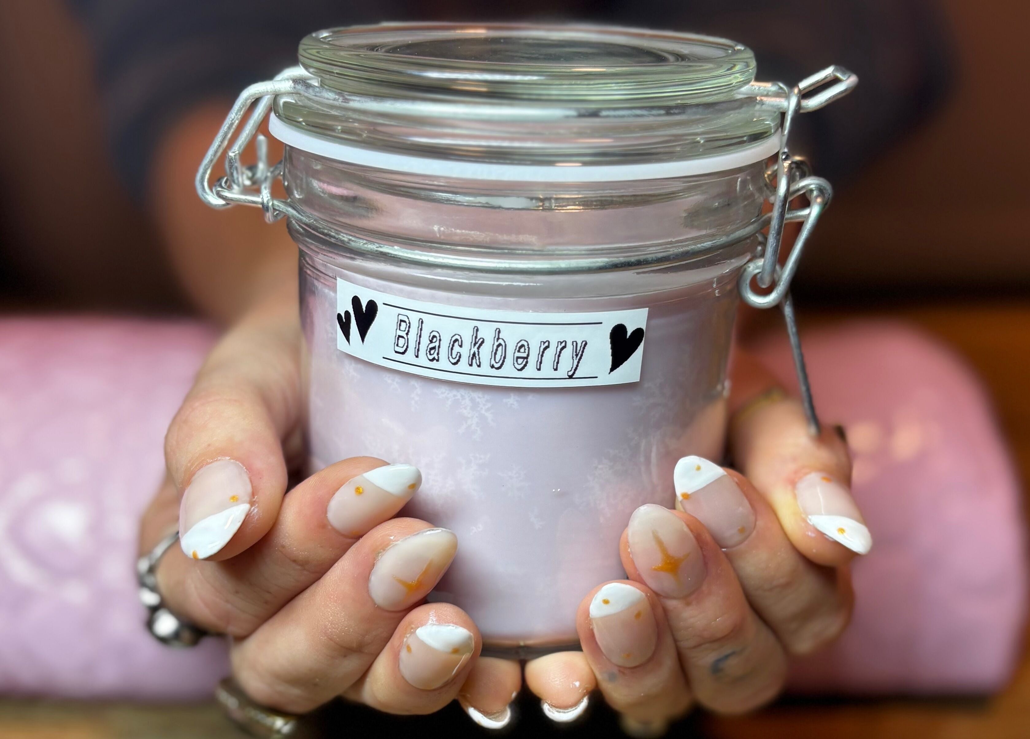Hand holding a glass jar of blackberry cream at Executive Elegance, Dunedin, Otago, NZ.