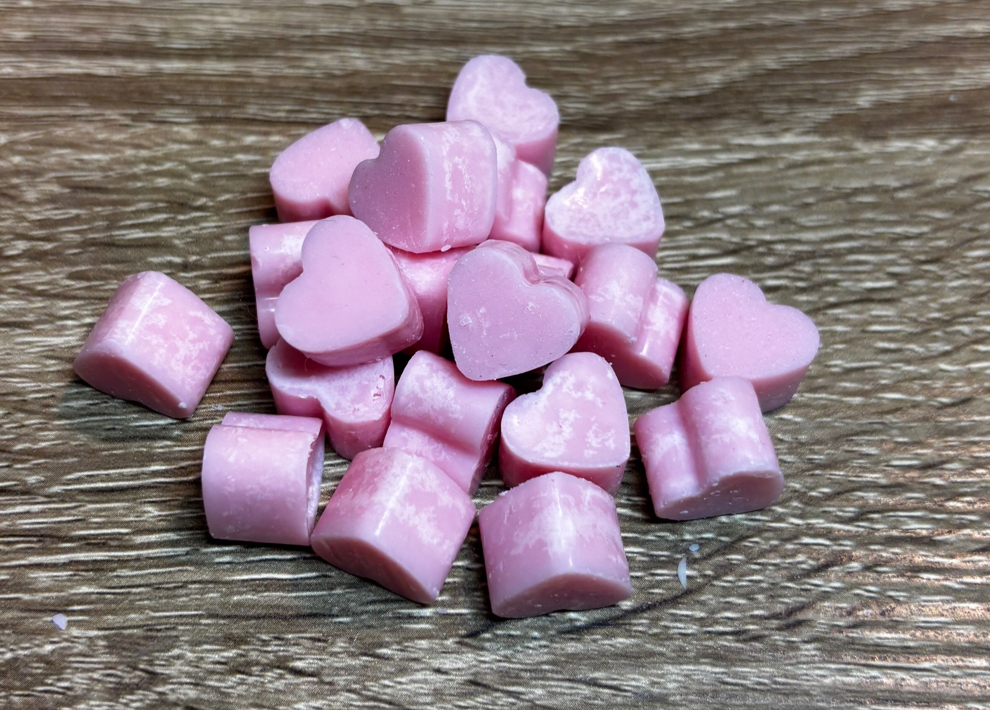 Pink heart-shaped candies on wooden surface at Executive Elegance, Dunedin, Otago, NZ.