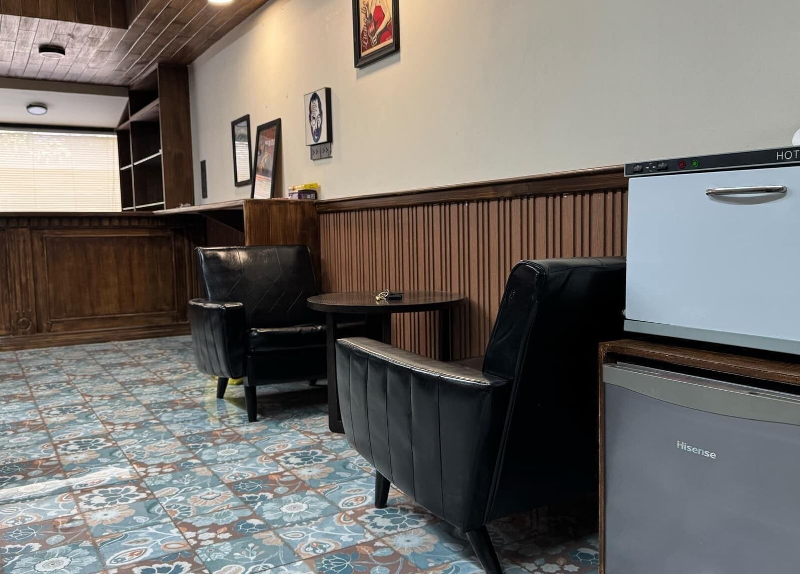 Elegant seating area in Liberty Grooming Lounge, Krung Thep Maha Nakhon, featuring stylish black leather chairs.