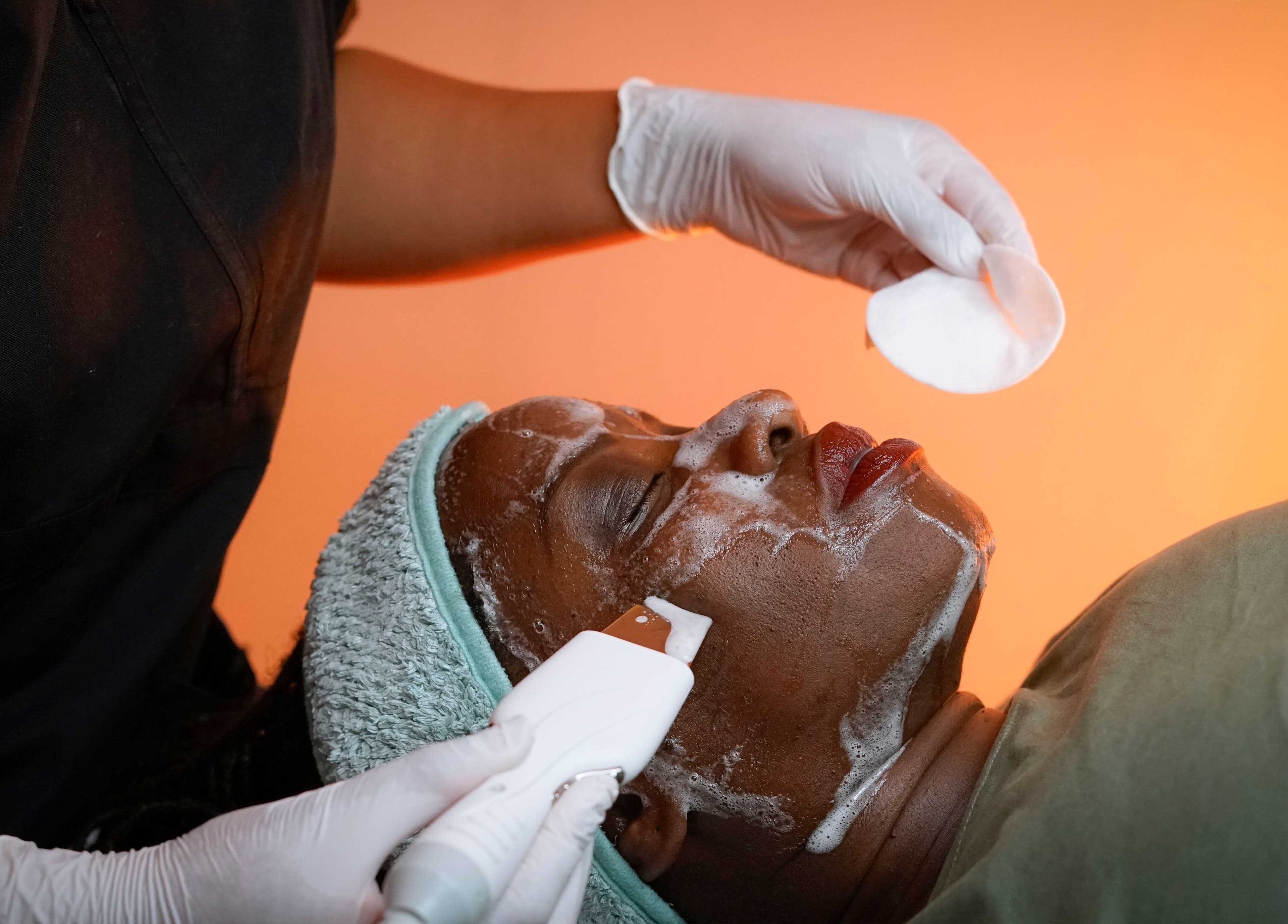 Facial treatment at Fine Line Studios, London, England, GB with cleansing foam and precision tool.