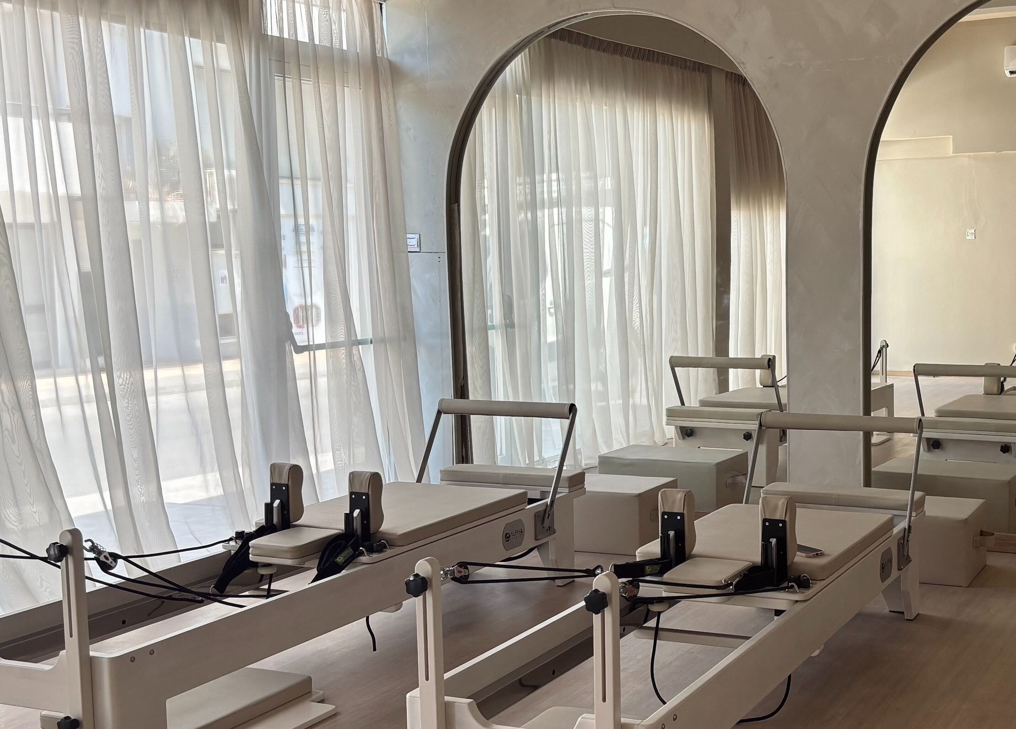 Pilates reformers at Aurora Pilates Studio, Strovolos, Lefkosia, CY with soft natural light filtering through curtains.