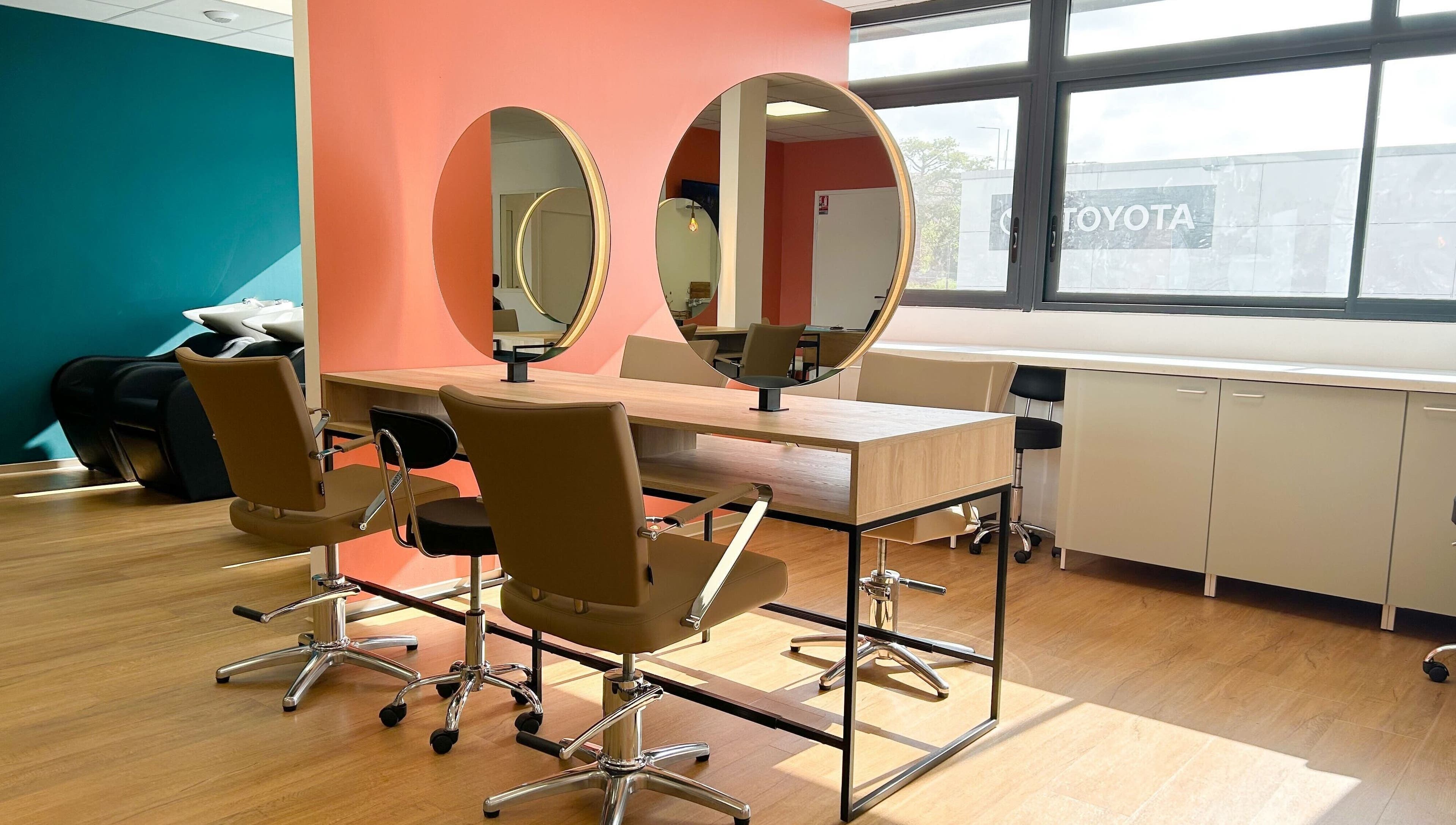 Intérieur moderne du salon Séléné à Le Lamentin, Martinique, FR avec miroirs circulaires et chaises élégantes.
