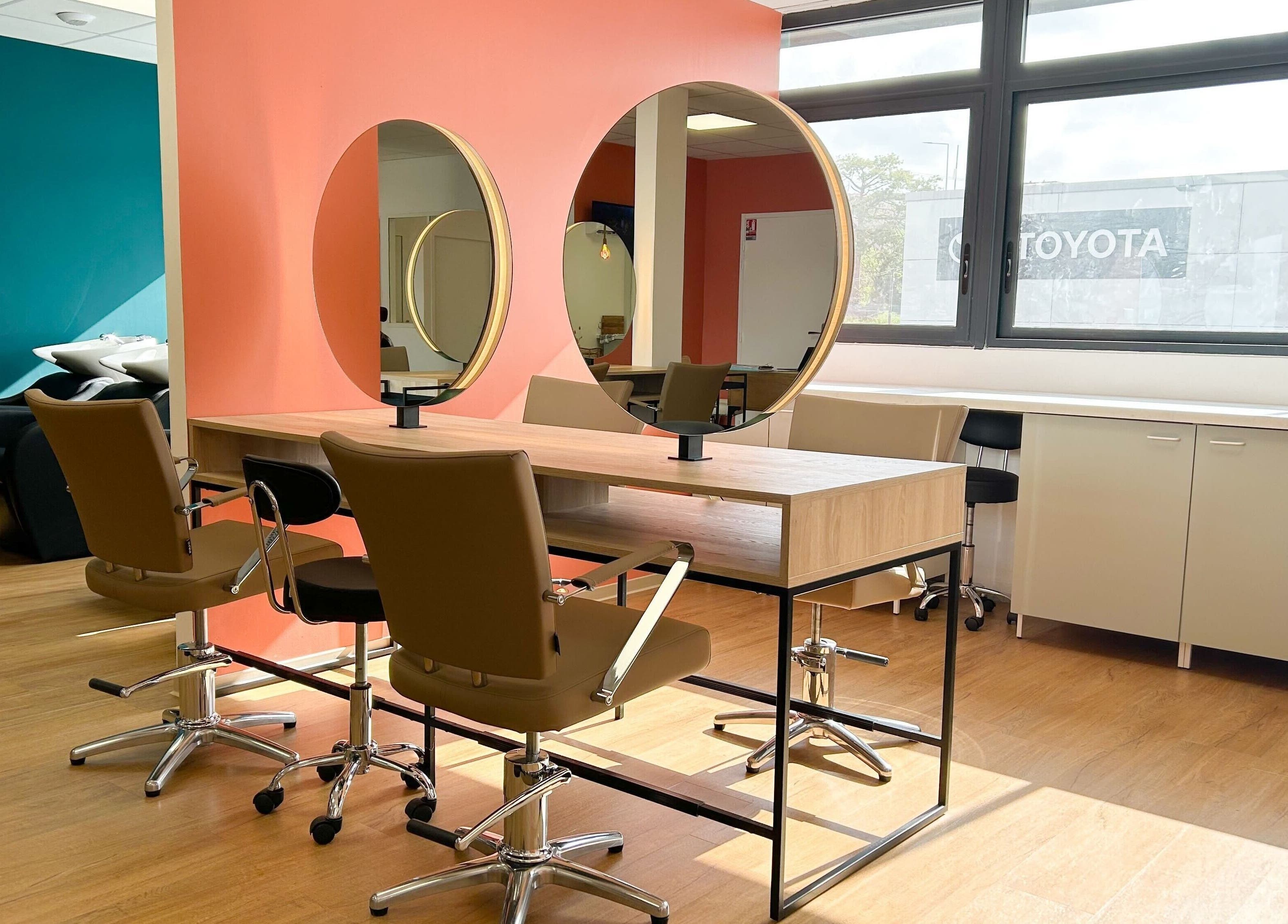 Intérieur moderne du salon Séléné à Le Lamentin, Martinique, FR avec miroirs circulaires et chaises élégantes.