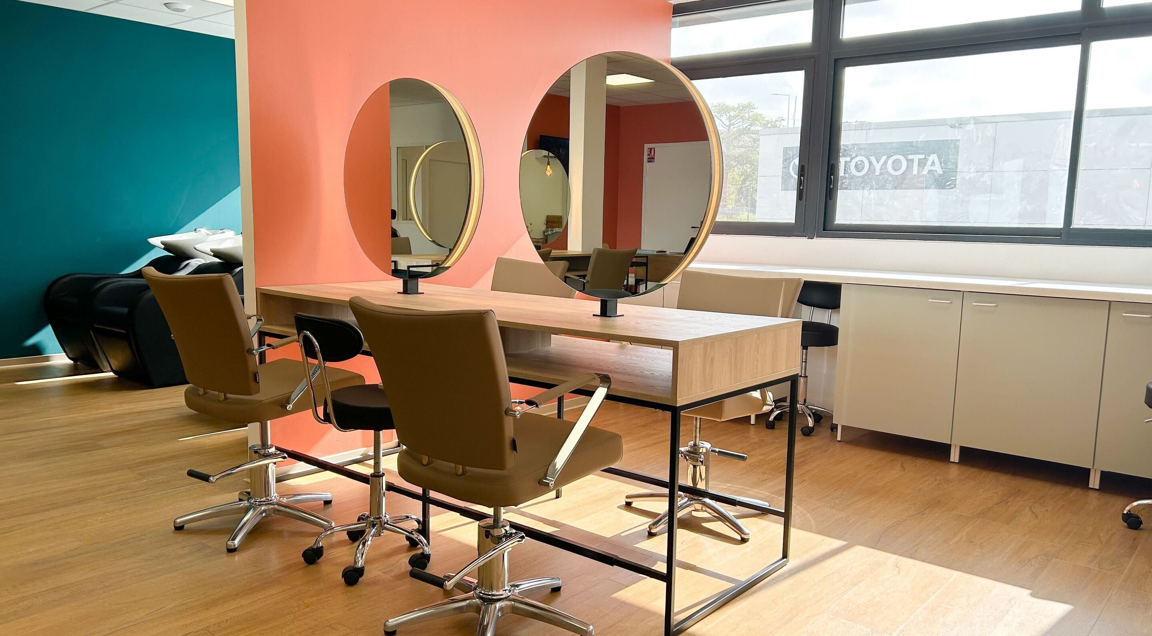 Intérieur moderne du salon Séléné à Le Lamentin, Martinique, FR avec miroirs circulaires et chaises élégantes.
