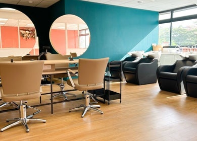 Intérieur élégant de Séléné à Le Lamentin, Martinique, FR avec miroirs ronds et fauteuils confortables.