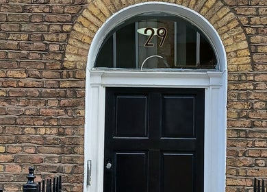Elegant entrance at Kaya's Beauty, London, England, GB featuring a classic black door with an arch.