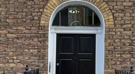 Elegant entrance at Kaya's Beauty, London, England, GB featuring a classic black door with an arch.