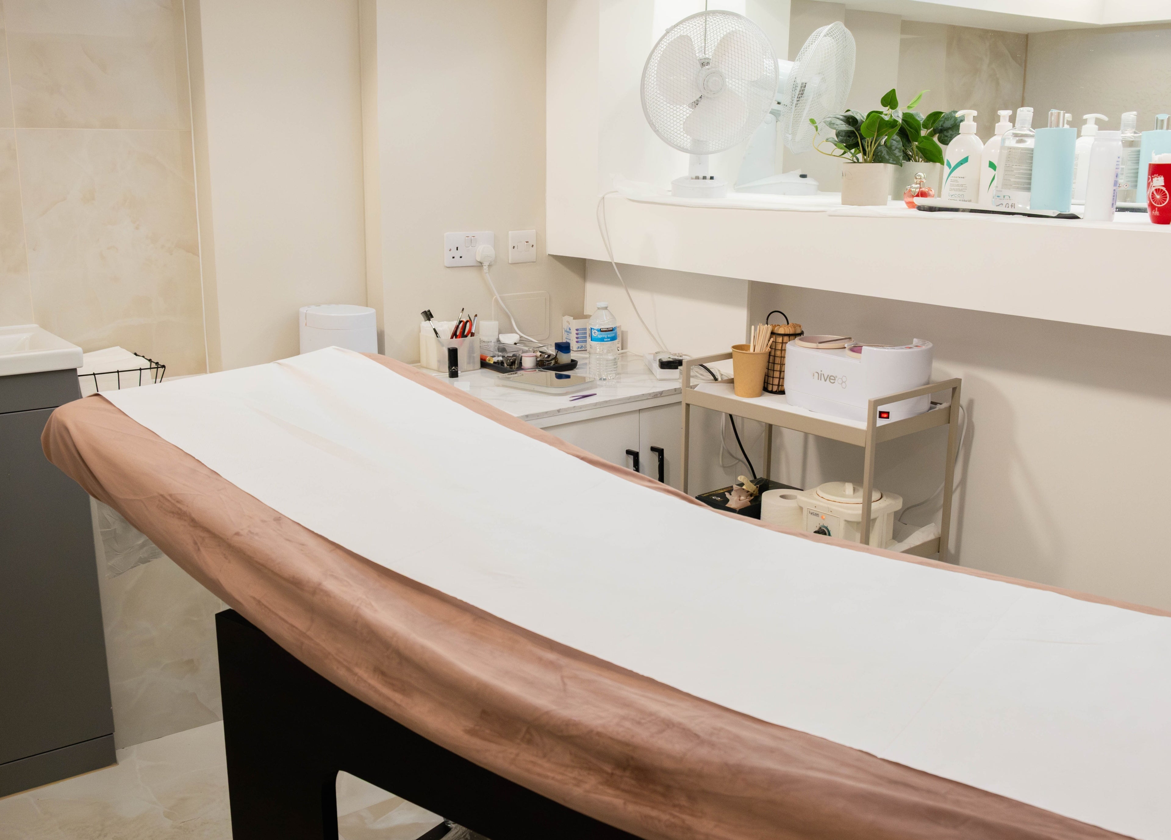 Cozy treatment room at Keo Spa, London, England, GB, featuring a massage table and beauty products.
