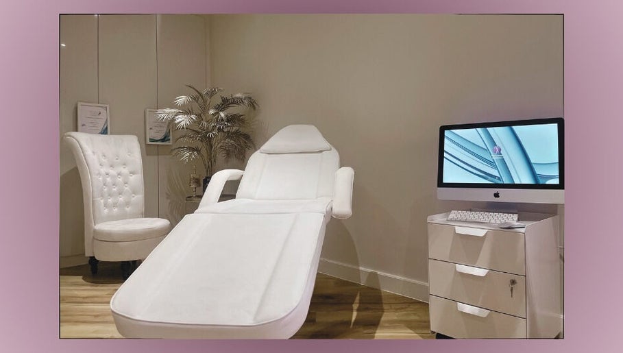 Relaxing treatment room at Divine London Aesthetics Clinic, London, England, GB with a plush chair and computer setup.