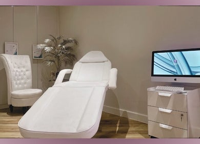 Relaxing treatment room at Divine London Aesthetics Clinic, London, England, GB with a plush chair and computer setup.