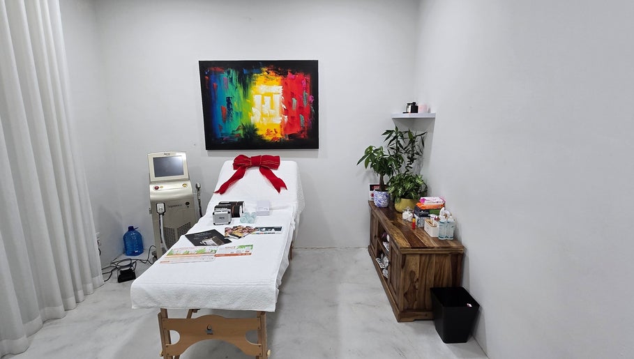Skash treatment room in Cape Town, Western Cape, ZA, with a bed, art, and plants for a serene experience.