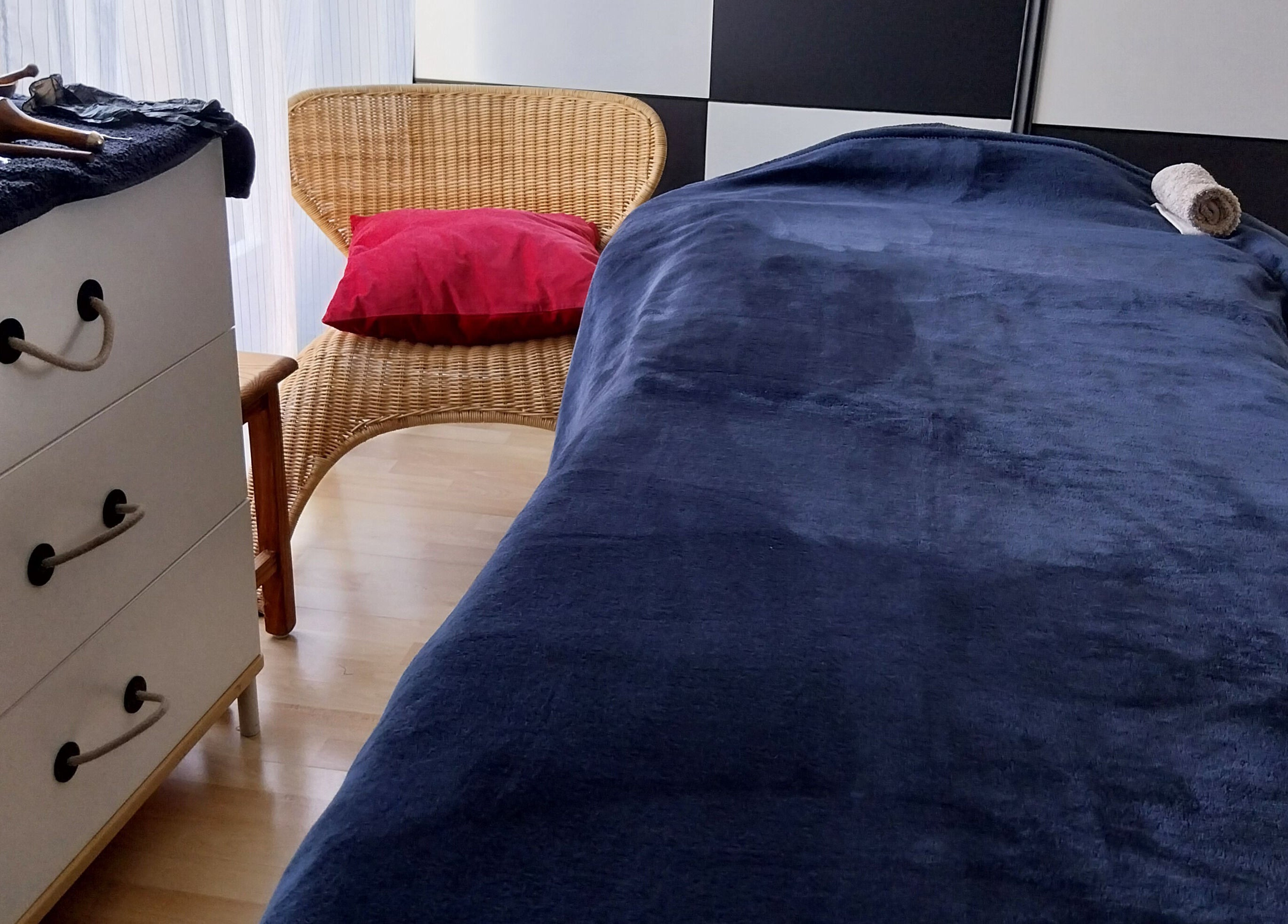 Salle de soin chez Nat & Sens, Maisons-laffitte, Île-de-france, FR, avec lit de massage bleu et chaise tressée.