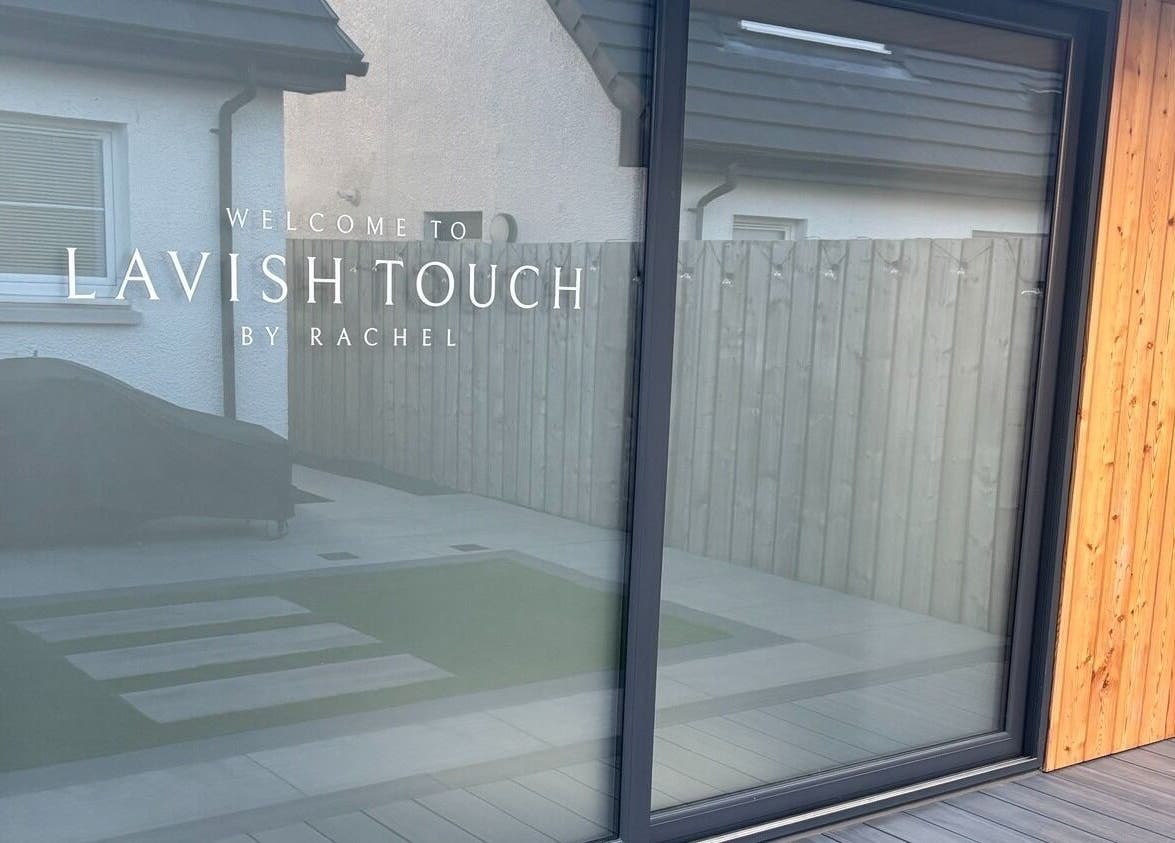 Entrance to Lavish Touch Dundee in Scotland, featuring a modern glass facade and warm wooden paneling.