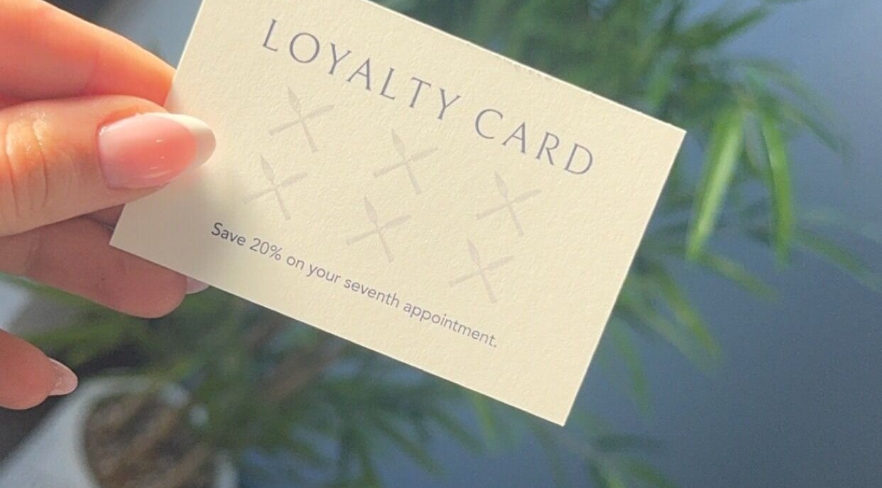 Close-up of Lavish Touch Dundee loyalty card in Dundee, Scotland, GB, offering 20% on seventh visit.