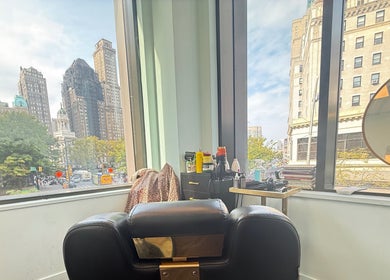 Chic styling chair at Silky | The Healthy Hair Experts, New York, New York, US, overlooking the cityscape.