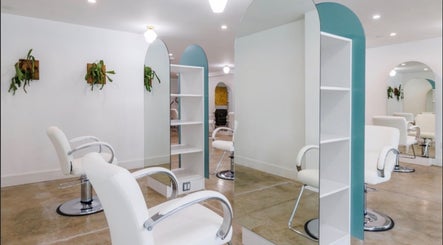 Modern salon interior at Silky | The Healthy Hair Experts in Brooklyn, New York, US, showcasing white chairs and mirrors.